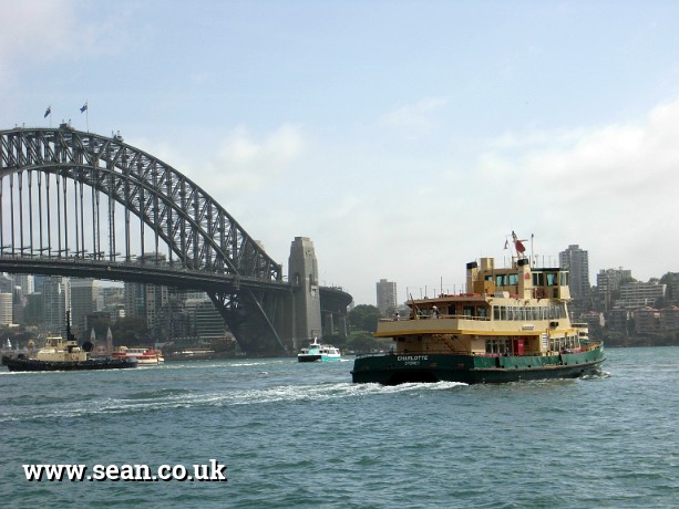 Photo of a ferry in front of Sydney Harbour Bridge in Australia