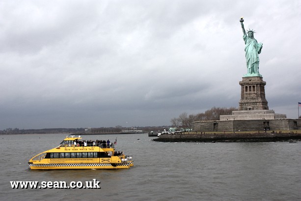 Photo of the Statue of Liberty and a New York water taxi in New York, USA