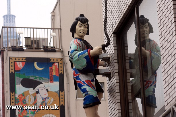 Photo of a Japanese figure on a building in Tokyo, Japan