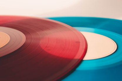 A red transparent vinyl record, sitting on top of a blue coloured record