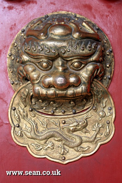 Photo of a lion and dragon door handle in the Forbidden City in China