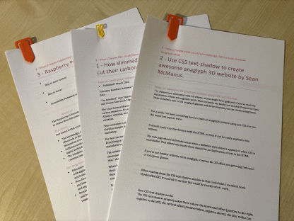 Photo of three print-outs of Word documents containing web pages.