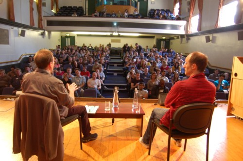 Paul Bassett Davies (left) and Robert Popper on stage looking out at the crowd at the London Comedy Writers Festival